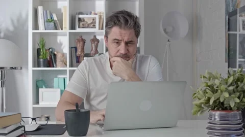 Middle aged man working with computer at home Stock Footage