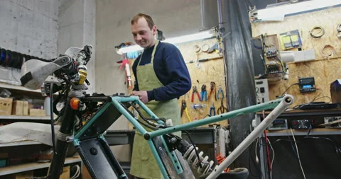 A middle-aged man is working on creating his new product for electric bicycles Stock Footage 148647298