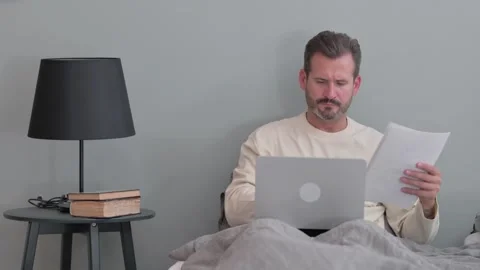 Middle Aged Man Working on Documents in Bed at Home 스톡 동영상 287899165