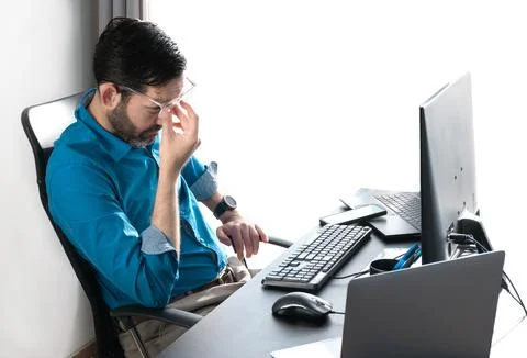 Middle-aged man working at home. Eye fatigue. Hand on nasal septum Stock Photos