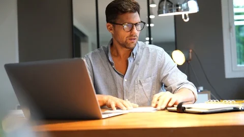 Middle-aged man working on laptop in office Stock Footage 117358881