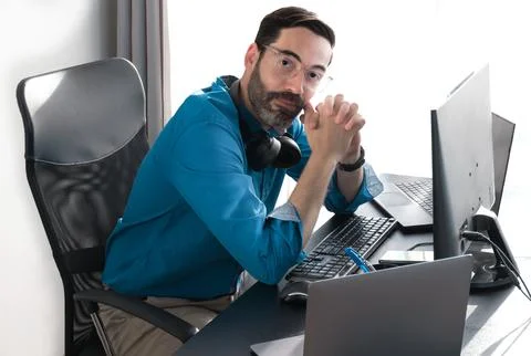 Middle aged man working in office. Hands fingers crossed. Looking at Stock Photos