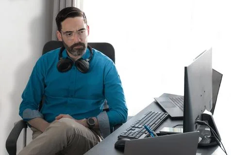 Middle-aged man working in an office about to disapprove. Frown Stock Photos