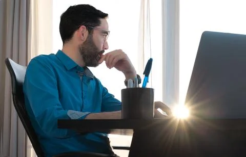 Middle-aged man working in office. Looking out of window. Finger in mouth Stock Photos