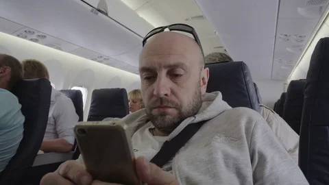 Middle-aged man working on the phone in airplane cabin . Video stock 81068534