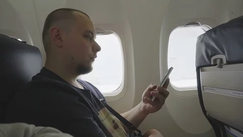 Middle-aged man working on the phone in airplane cabin . Stock Footage 81068833