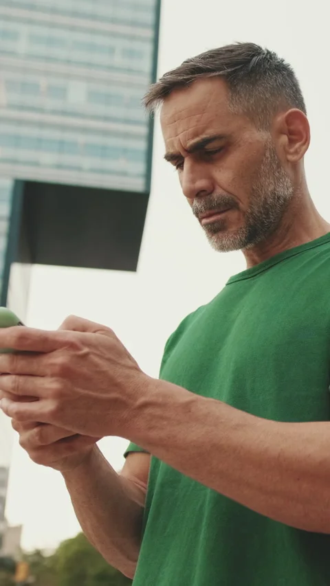 Middle-aged men using mobile phone outside on the street Stock Footage 244924820