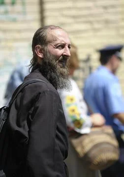 Middle aged monk in a cassock walking down the street, portrait. Kyiv, Ukrain Stock Photos