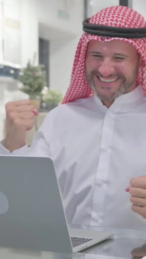 Middle Aged Muslim Man Celebrating Success while Doing Multitasking at Work, Stock Footage 324777435