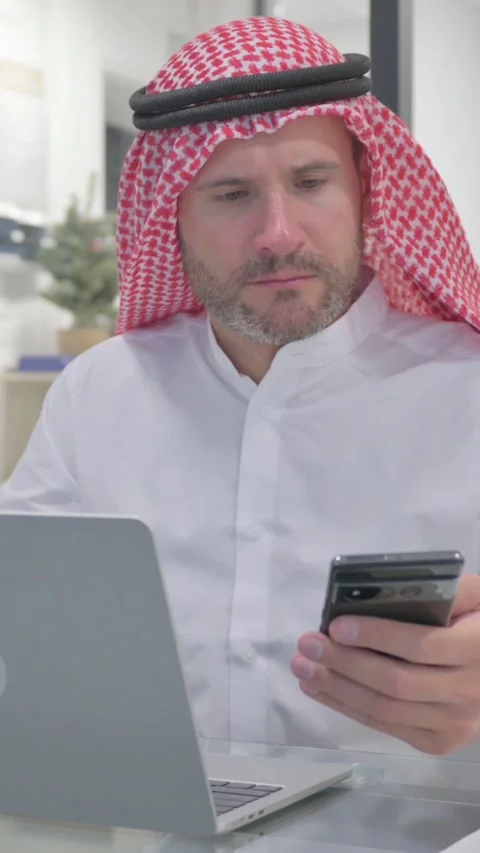 Middle Aged Muslim Man Working on Multiple Digital Devices at Work, vertical Stock Footage 324777459