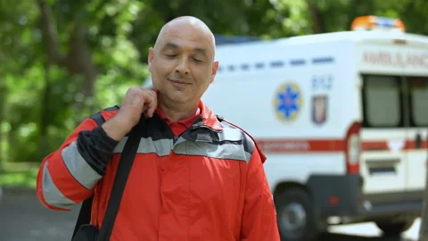 Middle-aged paramedic posing for camera, professional emergency medical service 스톡 동영상 97021714