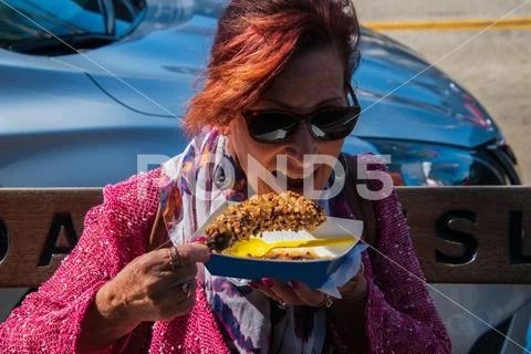 Middle aged pretty baby boomer woman with red hair red sweater colorful scarf Stock Photos