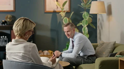 Middle-aged Psychologist Writing Notes during Therapy Session with Patient Stock Footage 340627715