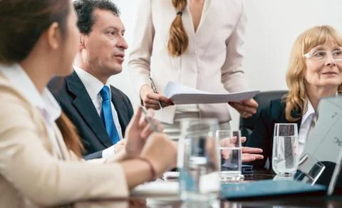 Middle-aged skilled manager cooperating with his colleagues Stock Photos