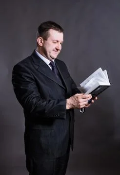 Middle aged solid tutor with book Foto stock