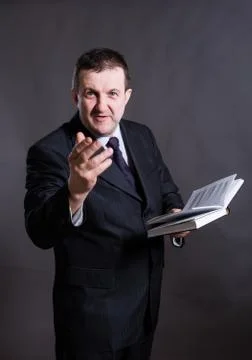 Middle aged solid tutor with book studio portrait. Stock Photos