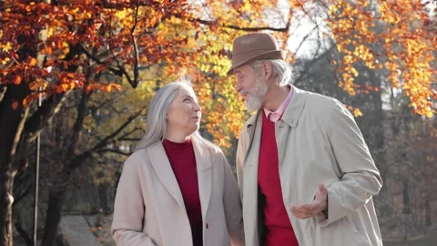Middle aged spouses enjoying time together in beautiful autumn park. Happy old Stock Footage 205084917