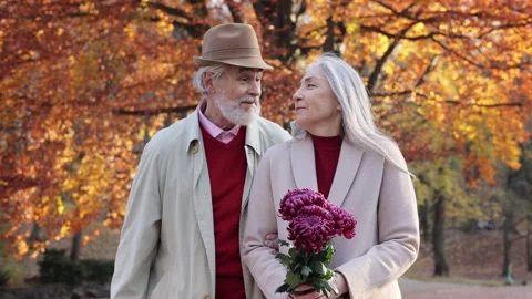 Middle aged spouses enjoying time together in beautiful autumn park. Happy old 스톡 동영상 205085061
