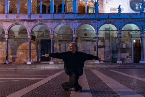 Middle-aged tai chi master showing stick exercises outdoors amidst the arch.. Stock Photos
