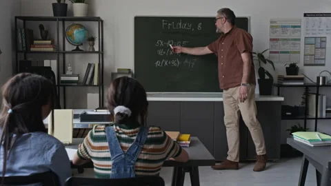 Middle-Aged Teacher Explaining Math Equations to Students Stock Footage 339671616