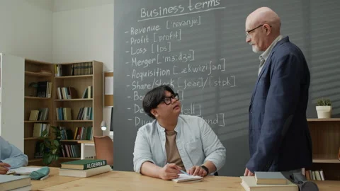 Middle-aged Teacher Helping Asian Migrant Student in Classroom Stock Footage 337491123