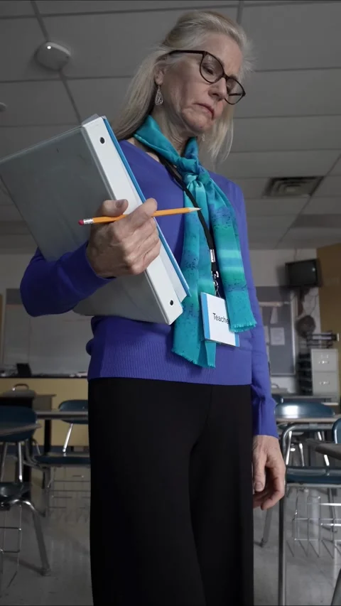 Middle Aged Teacher Prepares for Class in an Empty Classroom Setting 库存影片 306270642