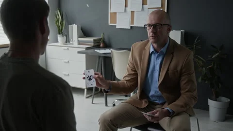 Middle Aged Therapist Showing Rorschach Inkblot Card to Male Patient Stock Footage 340645596