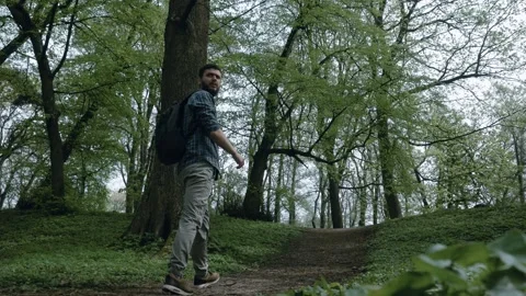 A middle-aged tourist with a backpack walks along a forest path Stock Footage 274225576
