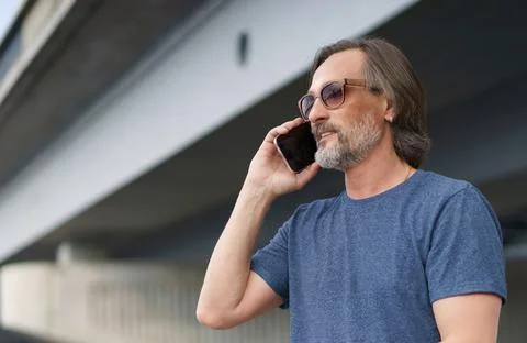 Middle aged using phone in city. Man on urban background talking on the phone Stock Photos