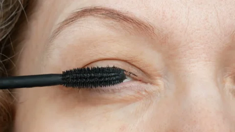 Middle-aged woman does corrective eye makeup to correct the drooping eyelid.  Stock Footage 154626592