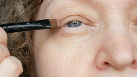 Middle-aged woman does corrective eye makeup to correct the drooping eyelid.  Stock Footage 162377756