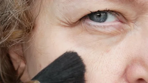 Middle-aged woman does makeup, woman with drooping eyelid. Ptosis is a droopi Stock Footage 165321920