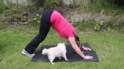 A middle aged woman doing exercises in her garden at home Stock Footage 245572276