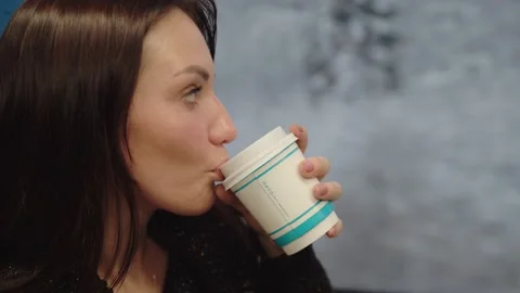 A middle-aged woman drinks coffee and dreamily looks out of the train window Stock Footage 199519661
