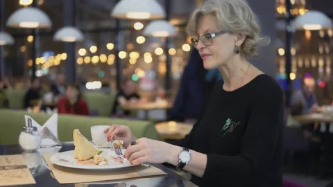 A middle-aged woman eats dessert in a cafe. Stock Footage 84990934