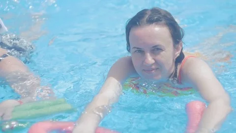 A middle-aged woman in the pool does water aerobics. Stock Footage