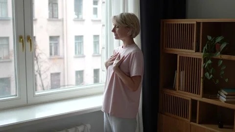 Middle aged woman practicing deep breathing exercise to reduce stress level and Vidéo 323818337