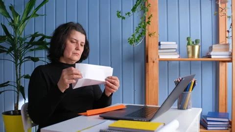 Middle aged woman reading document paper notice letter Video stock 155436542