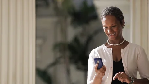Middle-aged woman smiling while using a smart phone. Stock Footage 88368860