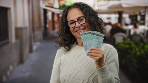 Middle-aged woman smiling while holding malaysian ringgit banknotes on a re.. Stock Footage 306850177