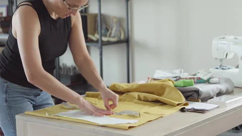 Middle aged woman tailor precisely sewing clothing patterns in small business fa Stock-Footage 315427799