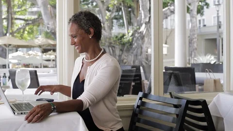 Middle-aged woman using a laptop in a restaurant. 스톡 동영상 88368984