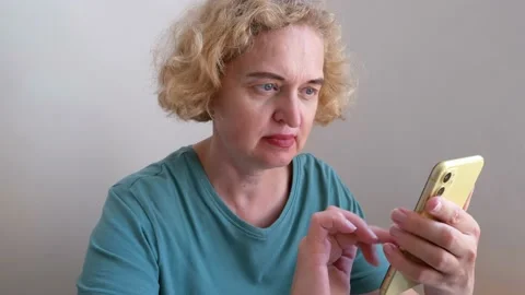 Middle aged woman using smart phone at home, female using smartphone mobile.. Stock Footage 230255939