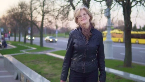 A middle-aged woman walking down the street smiling. Slow-motion Stock Footage 74479423