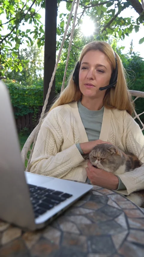 Middle aged woman working remotely with laptop and cat Stock Footage 317981066