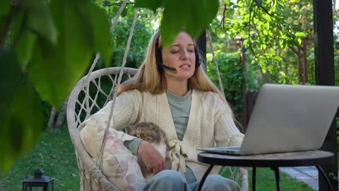 Middle aged woman working remotely with laptop and cat Stock Footage 329668864