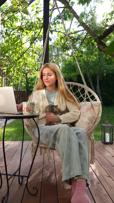 Middle aged woman working remotely with laptop and cat Stock Footage 329669107