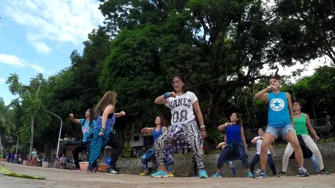 Middle aged women dance zumba at lake shore Stock Footage
