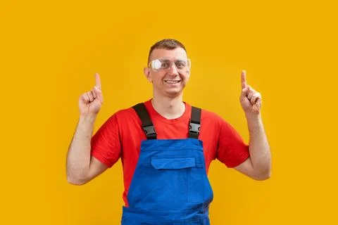 Middle-aged worker man or builder wears uniform and points his index fingers  Фото