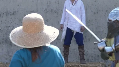 Middle Ages combat. Two men dressing iron armour fight a sword-fired duel. Video stock 76235976